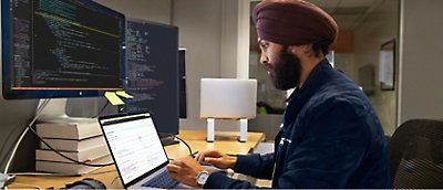 En mann i turban jobber på en datamaskin