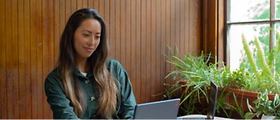 Een jonge vrouw die aan een tafel zit met een laptop.