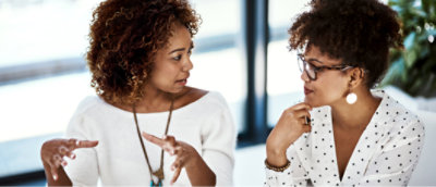 两位女士在办公室里互相交谈。