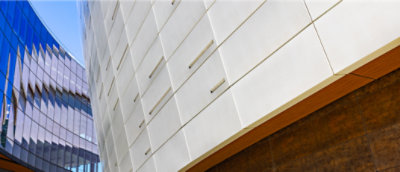 Exterior view showing the juxtaposition of two modern buildings with sleek, angular designs and different facade materials.