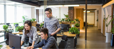 Two men and a women working in a office