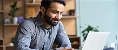 A man looking to a laptop with smiling face