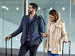 Ein Mann und eine Frau mit Gepäck in einem Flughafen.