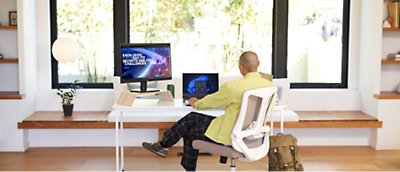 Un homme assis à un bureau devant une fenêtre.