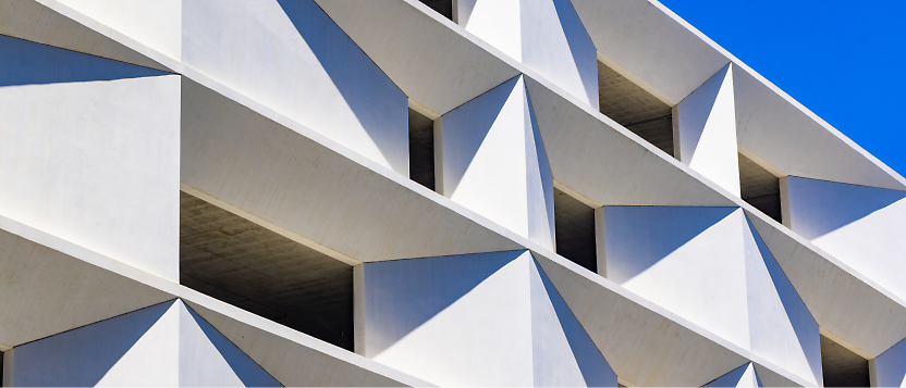 Geometric pattern of a modern building facade against a clear blue sky.