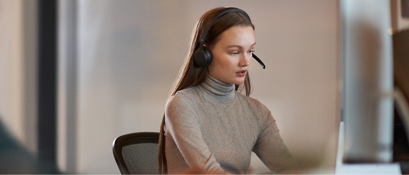A woman wearing a headset in an office.