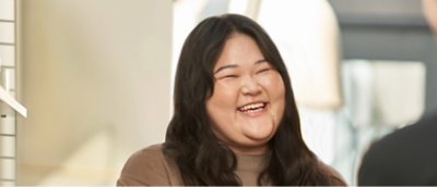 An asian woman laughing with another woman.