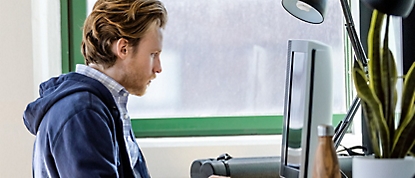 一個人坐著並使用電腦工作。