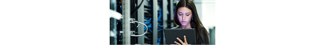 Una mujer usando una tableta en una sala de servidores.