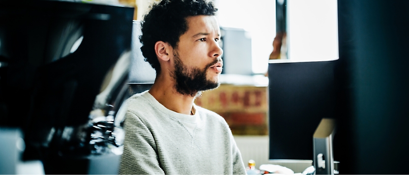 A person looking into his computer and the picture taken from the side view