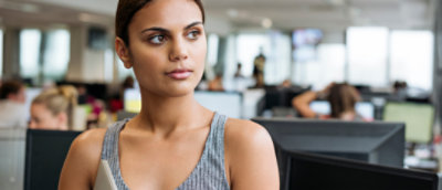 A woman in an office looking at her phone.
