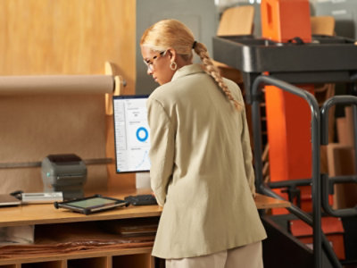 Person standing at a workstation and using a touchscreen device