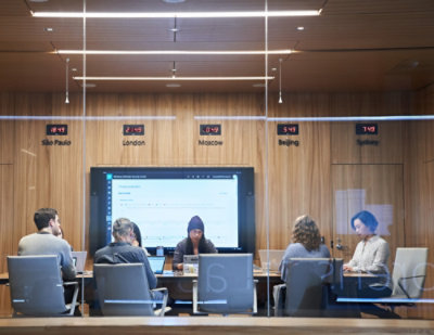 A group of people sitting at table with laptops.