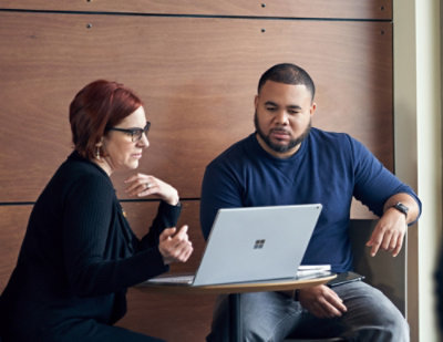 Two people looking at the laptop.