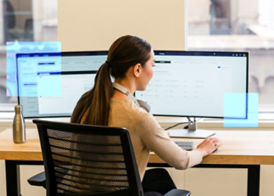 A woman sitting at a desk using a computer.