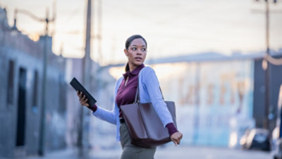 A woman walking with a tablet in hand