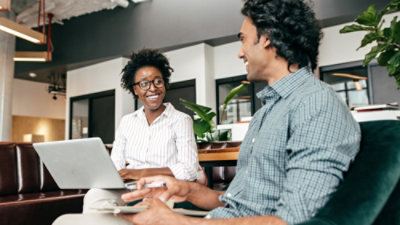 Person collaborating at table with laptops and phone