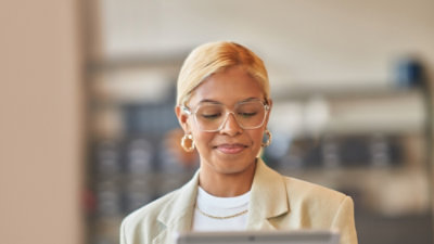 A woman looking at a tablet and smiling.