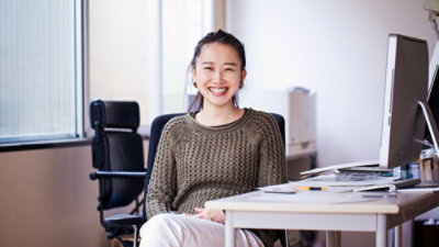 Women sitting down smiling.