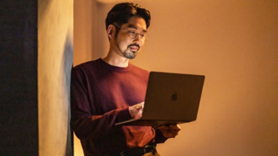 Person using a laptop standing.