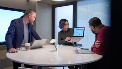 A group of people looking at the laptop.