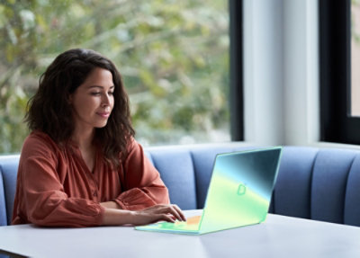 A person sitting at a table using a laptop.