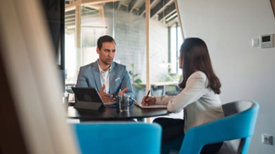 A woman and man reviewing documents and using tablet