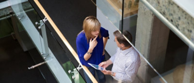 Coworkers using a tablet in an office building
