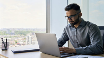 A person sitting at a desk using a laptop.