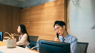 A person sitting and looking at their mobile device