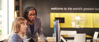 Two women looking at the computer screen.