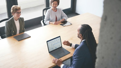 Work colleagues using laptops in a conference room