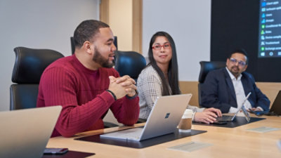 Conference room with a team working on laptops