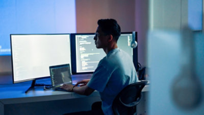 A man sitting at a desk with a laptop.