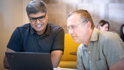 Two people looking at the laptop