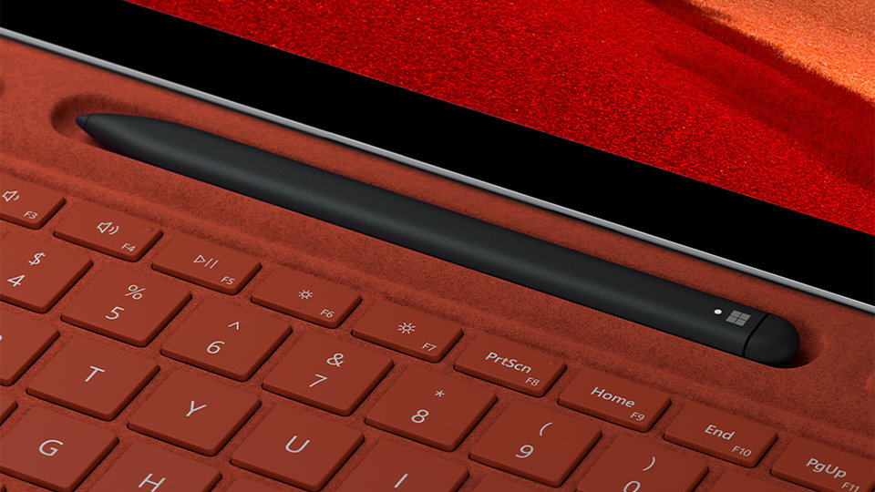 Close up view of Surface Slim Pen 2 for Business stored inside a Surface Pro Signature Keyboard charging dock at top of keyboard.