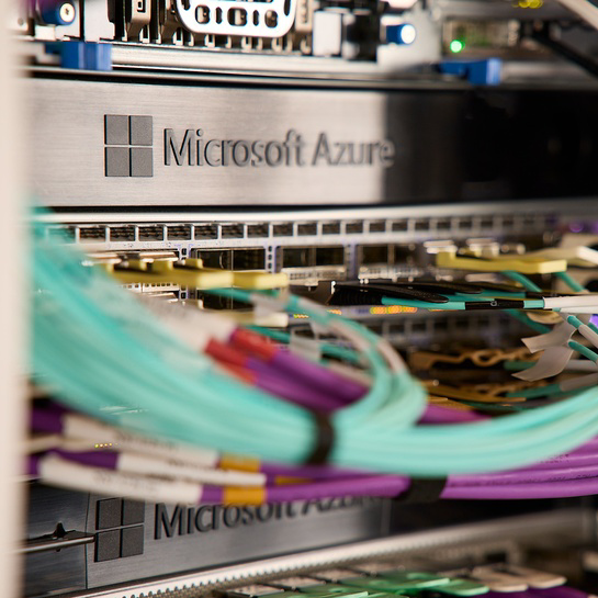 Close-up of Microsoft Azure network hardware with connected fiber optic cables in a data center environment.