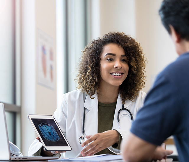 Doctor talking with a patient using a tablet. Healthcare.