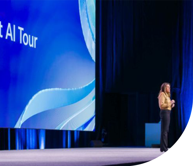 Speaker presenting on stage at the Microsoft AI Tour with event branding.
