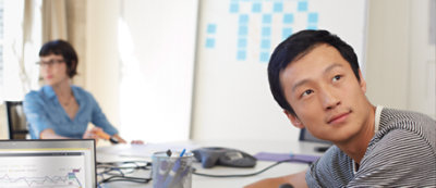 A person sitting at a table with a computer