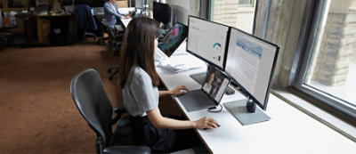 A person sitting at a desk with multiple computers