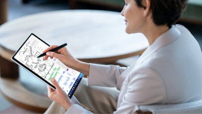 A person holding a tablet and a stylus