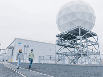 電気通信ビルの外を歩いている 2 人