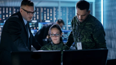Three government workers looking at a monitor