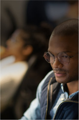 A close-up of a person's face wearing glasses.