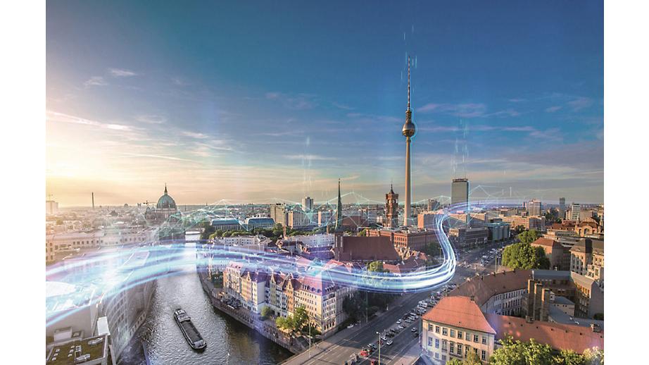 Es ist eine Luftaufnahme von Berlin zu sehen. Eingefügte Illustrationen sollen die Digitalisierung symbolisieren.