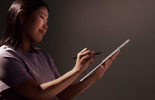 法人向け Surface スリム ペン で Surface デバイスのタッチスクリーンに描画する人。