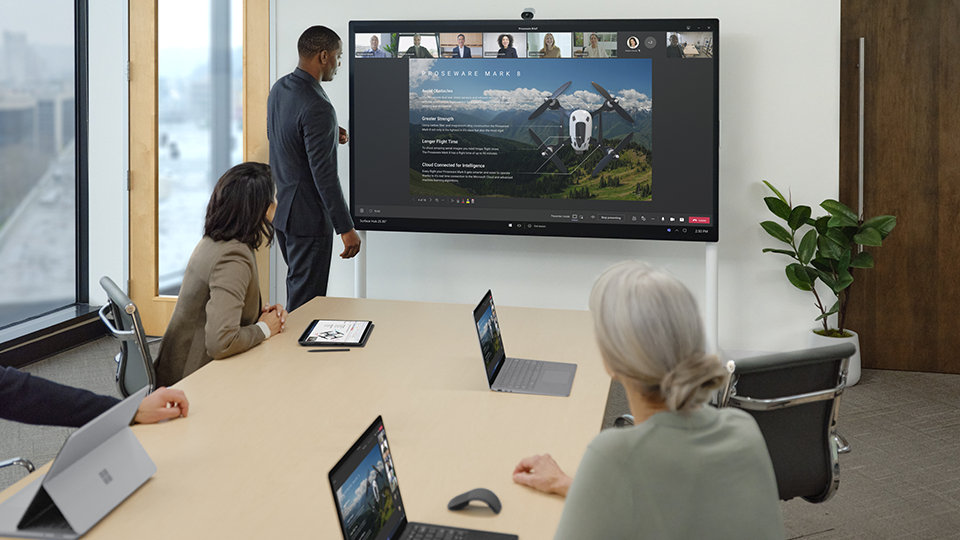 Meeting with people displaying Surface Hub 2 Camera above the screen which contains a screen image of a drone	