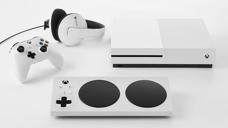 Une manette adaptative Xbox, une Xbox One, une manette sans fil Xbox et des écouteurs.