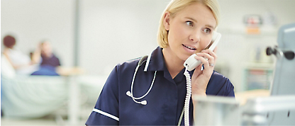 En skötare som pratar i telefon på ett sjukhus.